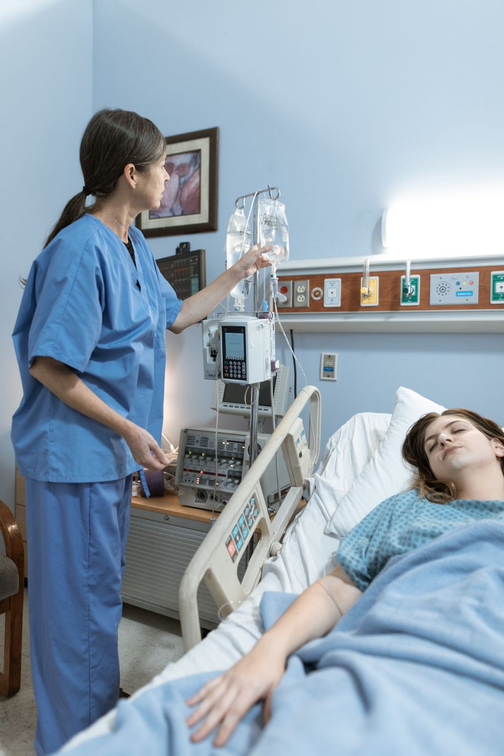 A nurse attending to a patient at the bedside