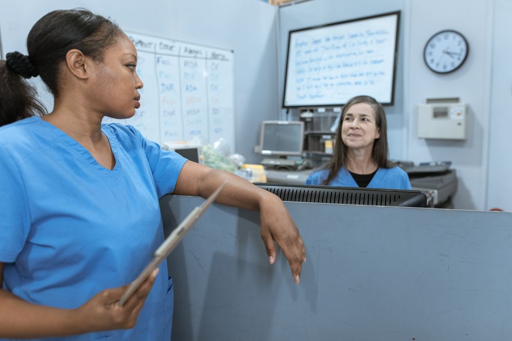 Two nurses reviewing information at a hospital workstation